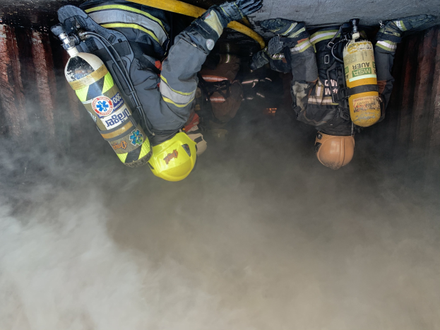 Feuerwehrleute in Schutzausrästung arbeiten daran, ein Tunnelbrand zu löschen.