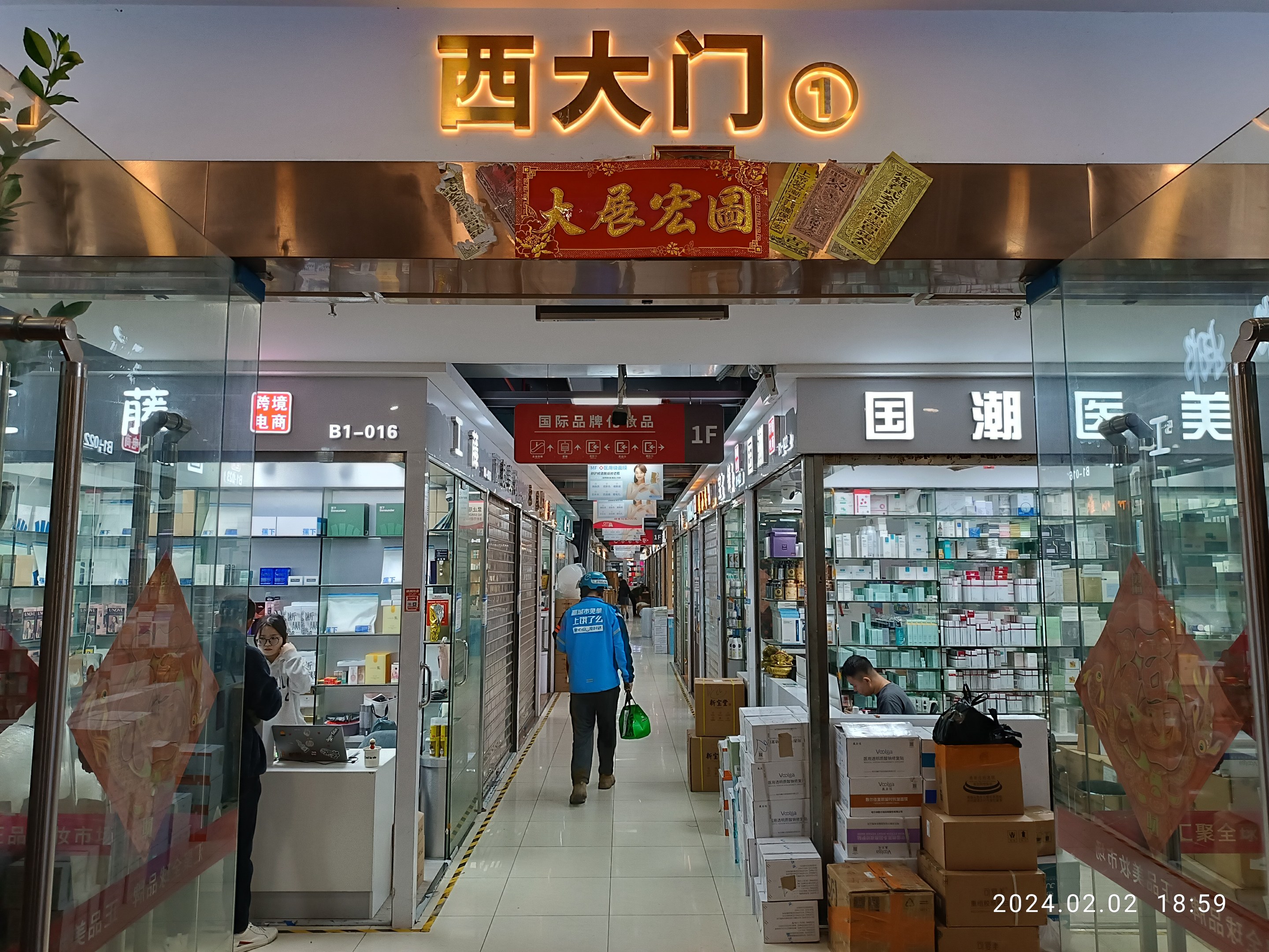 Innenansicht einer chinesischen Apotheke mit Glaswänden, einer Pflanze links, Regalen voller Artikel, verstreuten Kartons und Gegenständen auf dem Boden und einem Namensschild oben, das darauf hinweist, dass es ein chinesischer Drogeriemarkt ist.