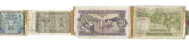 Ein Stapel alter deutscher Banknoten verschiedener Nennwerte auf einem alten Buch.