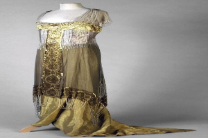 Eine Schaufensterpuppe in einem goldenen und silbernen Abendkleid aus den 1920er Jahren mit aufwendiger Goldstickerei und Perlen