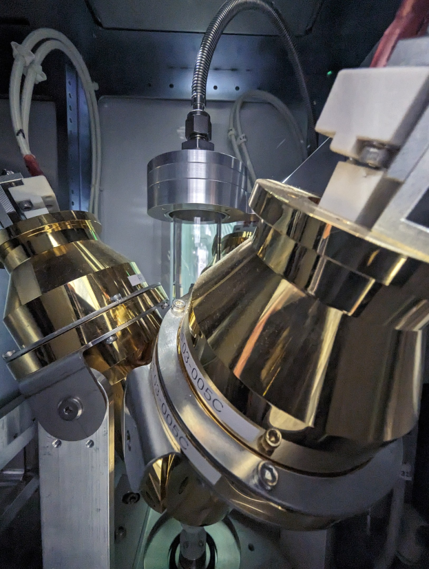 CNC-Fräsmaschine in einer Fabrik mit einem Metallobjekt im Vordergrund und einer Wand im Hintergrund, die verschiedene Werkzeuge und Komponenten zeigt, die mit dem Metallobjekt verbunden sind.