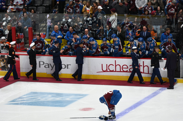 Ein Hockey-Spieler auf dem Eis umgeben von Fans und Team-Mitarbeitern während eines Spiels zwischen Colorado Avalanche und San Jose Sharks am 24. März 2015.