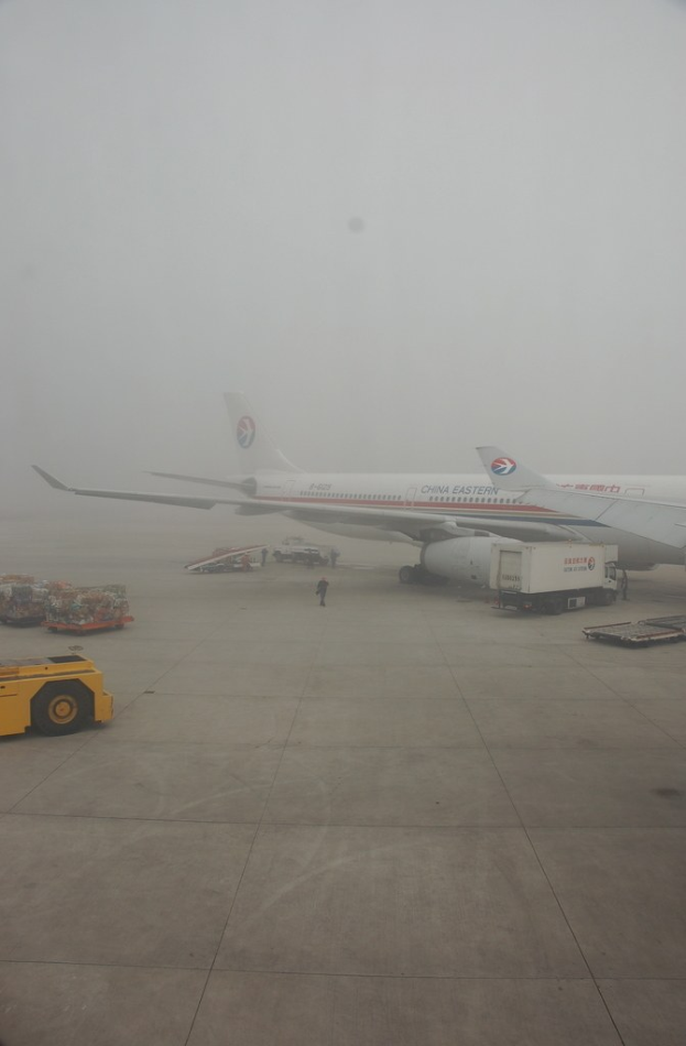 Flugzeug und Fahrzeuge auf einer Landebahn.