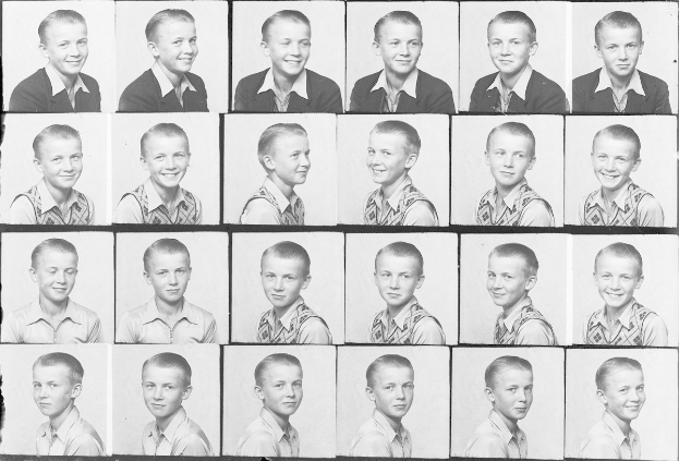 Ein Schwarz-Weiß-Foto eines strahlenden jungen Jungen mit ordentlich gekämmtem Haar, hellen Augen und einem glücklichen Ausdruck.