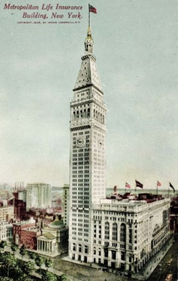 Schwarz-weiß-Postkarte des Metropolitan Life Insurance Building in New York City, die eine belebte Stadtkulisse mit mehreren Gebäuden, Bäumen und Fahrzeugen auf der Straße sowie den Text "Metropolitan Life Insurance" oben zeigt.