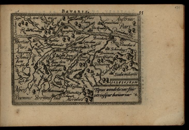 Altes Buch mit einer detaillierten Karte von Bayern auf dem Cover vor schwarzem Hintergrund.