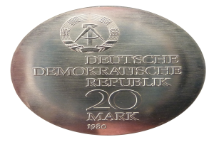 Silberne Medaille mit der Aufschrift 'Deutsche Demokratische Republik' vor weißem Hintergrund.