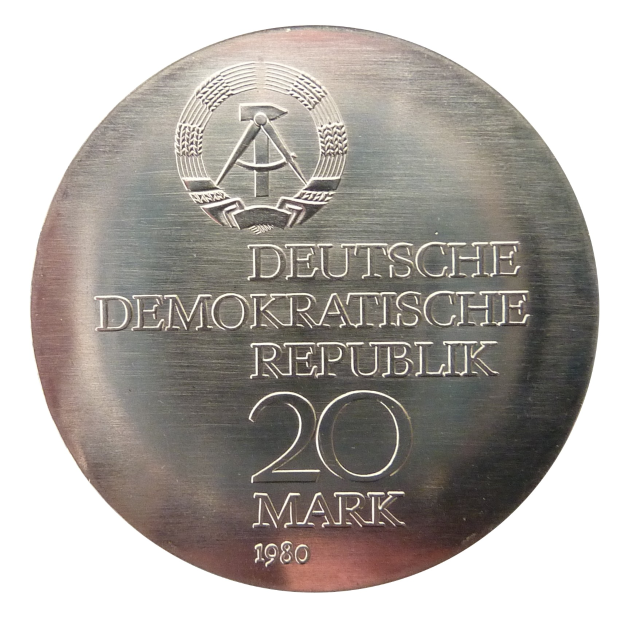 Silberne Medaille mit der Aufschrift 'Deutsche Demokratische Republik' vor weißem Hintergrund.