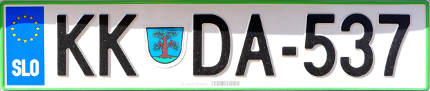 Weißer Hintergrund mit einem Kennzeichen, das den Text 'KDA-537' anzeigt und ein Bild eines Baumes.