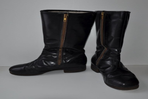 Schwarze Lederstiefel mit silbernen Reißverschlüssen auf einem weißen Hintergrund, mit einem glänzenden Finish und einem schlanken Design.