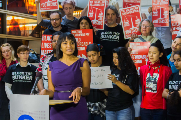 Eine Black Lives Matter-Aktivistin spricht vor einem Publikum mit Mikrofon.