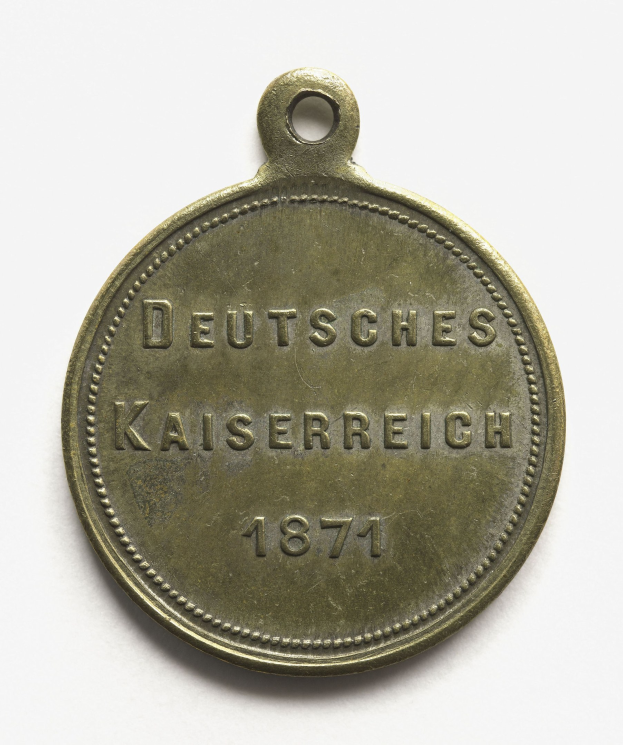Bronzemedaille mit der Inschrift "Deutsches Kaiserreich 1871" vor einem weißen Hintergrund.