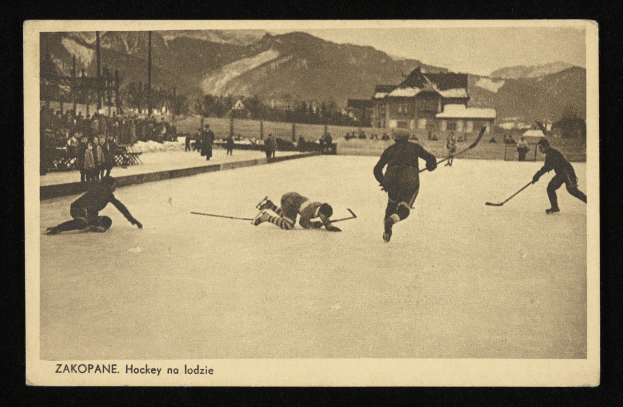 Schwarzes und weißes Foto von Menschen, die Hockey auf einem Eisstadion mit Gebäuden, Bäumen, Pfählen und Bergen im Hintergrund spielen, einschließlich Text unten.