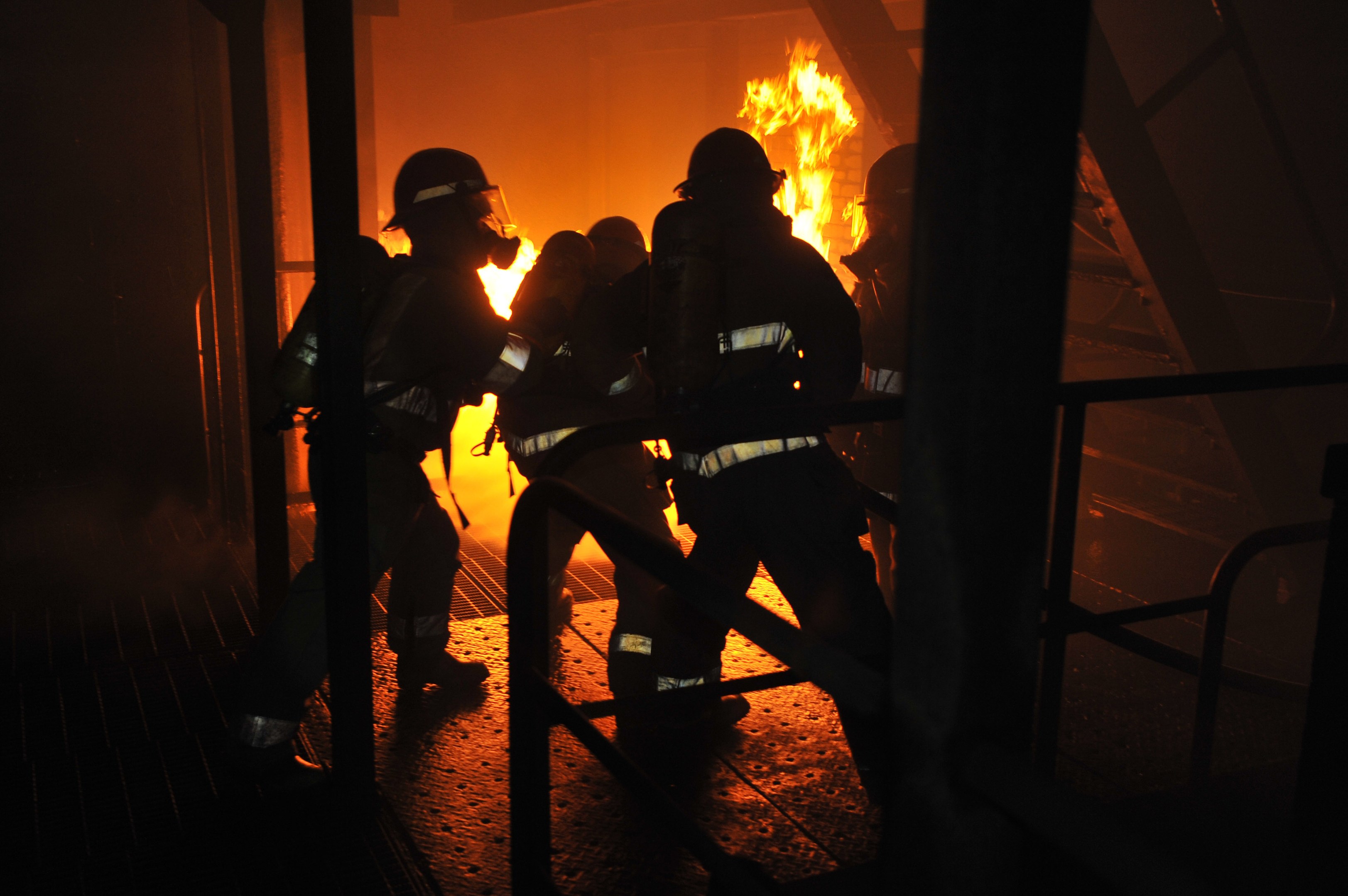 Feuerwehrleute in Schutzausrüstung vor einem brennenden Gebäude