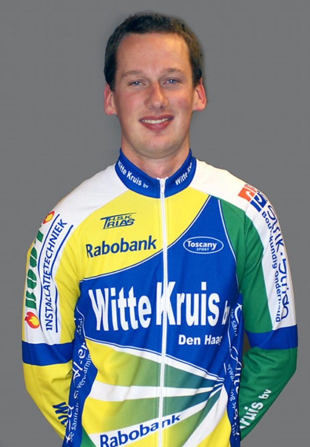 Ein männlicher Athlet posiert für ein Foto mit sichtbaren Sponsoren-Logos auf seinem Hemd.